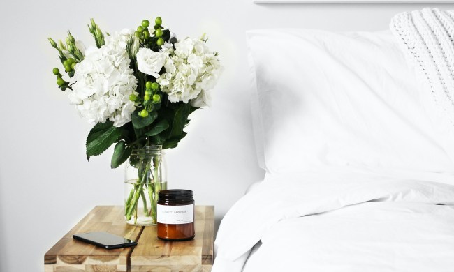 White flowers in a vase on a nightstand