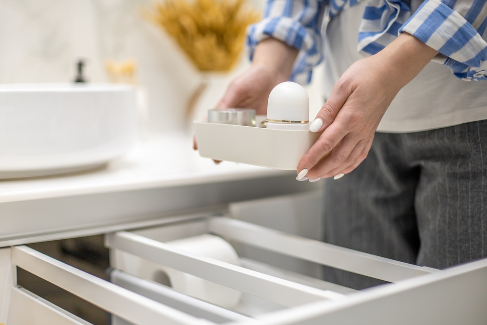 Person holding small tray of bathroom essentials