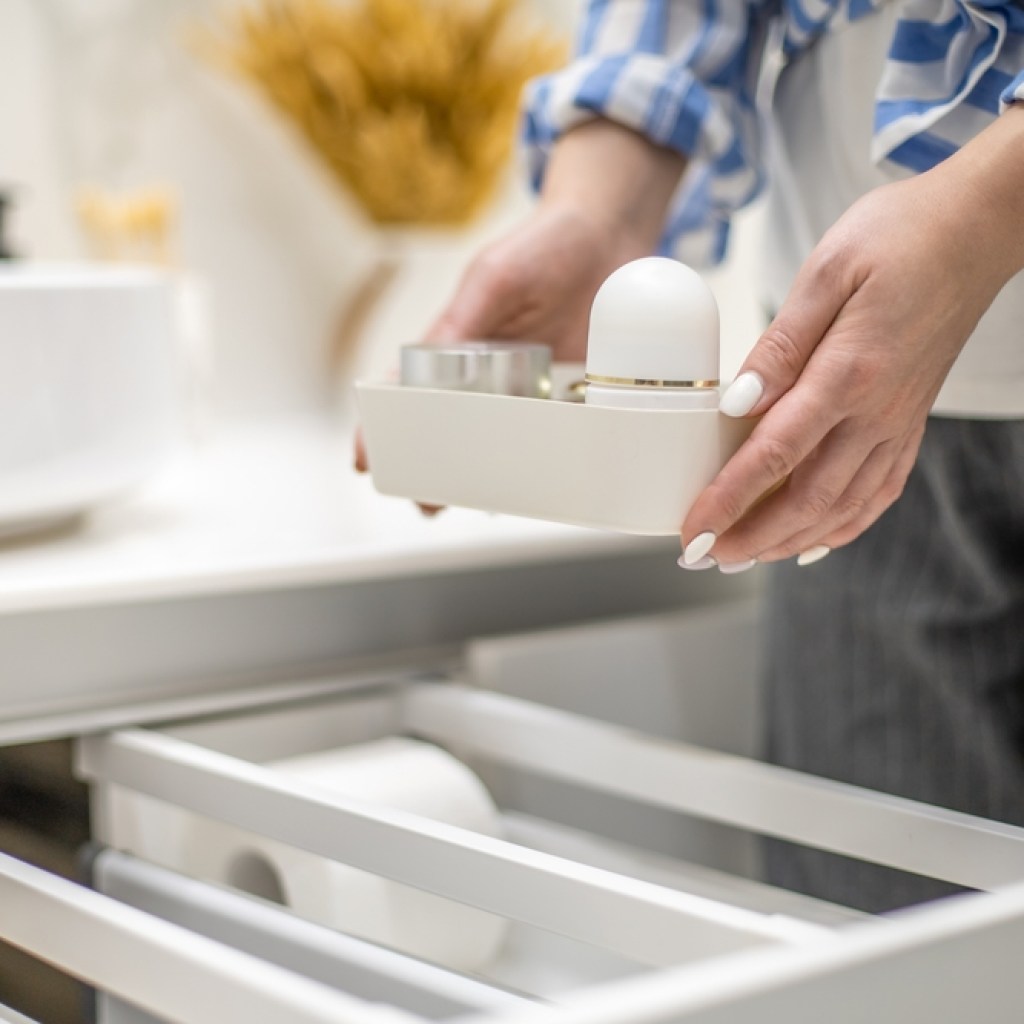 Person holding small tray of bathroom essentials