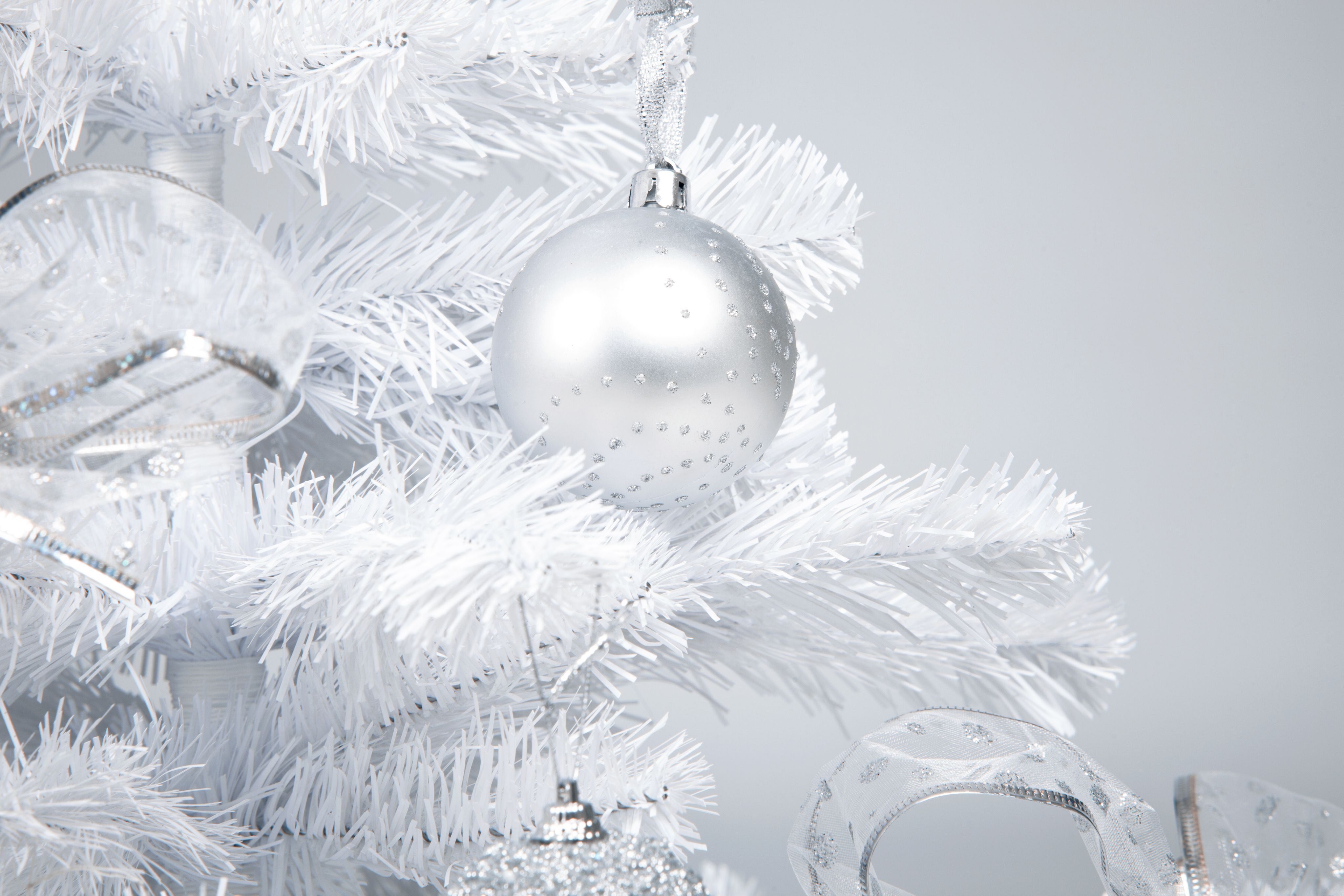 Silver ball ornament on a white Christmas tree