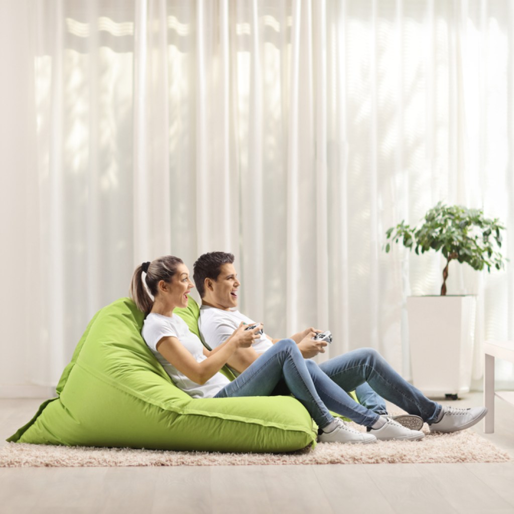 A couple playing video games in a bean bag chair