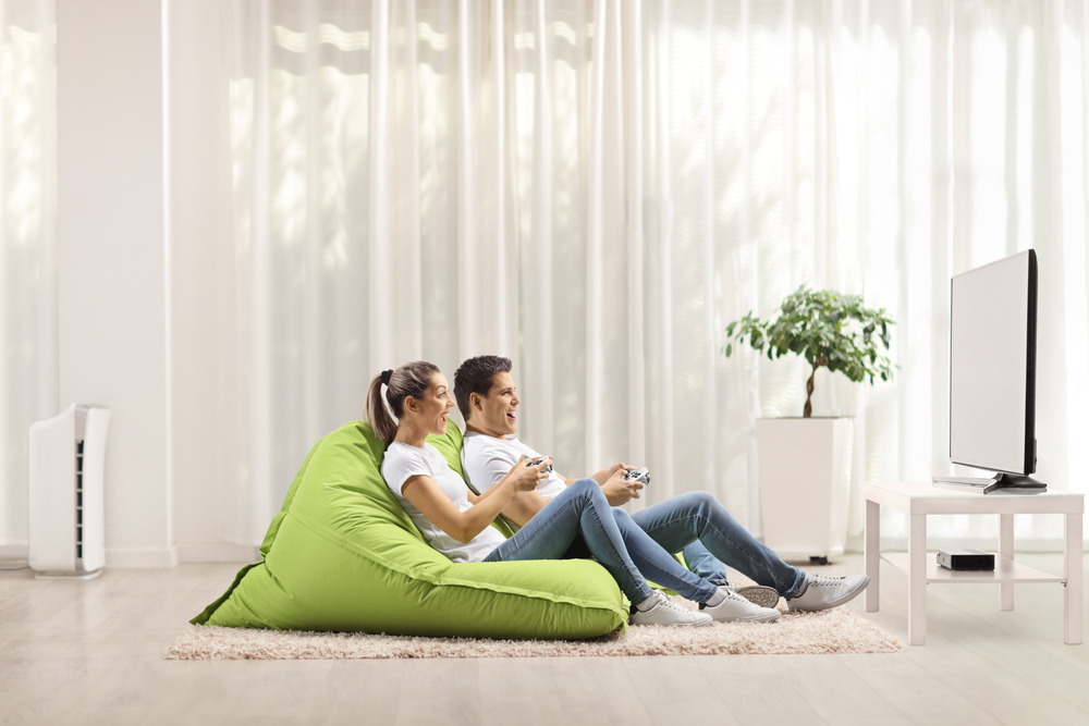 A couple playing video games in a bean bag chair