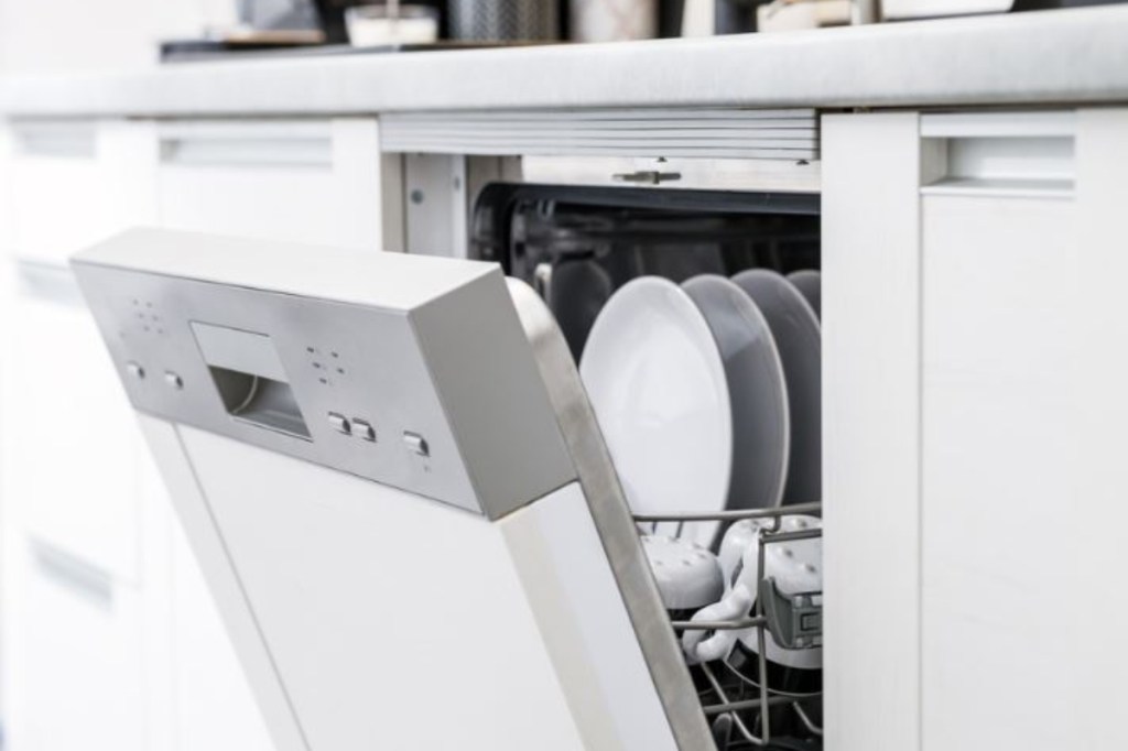 Open dishwasher in kitchen with clean dishes inside