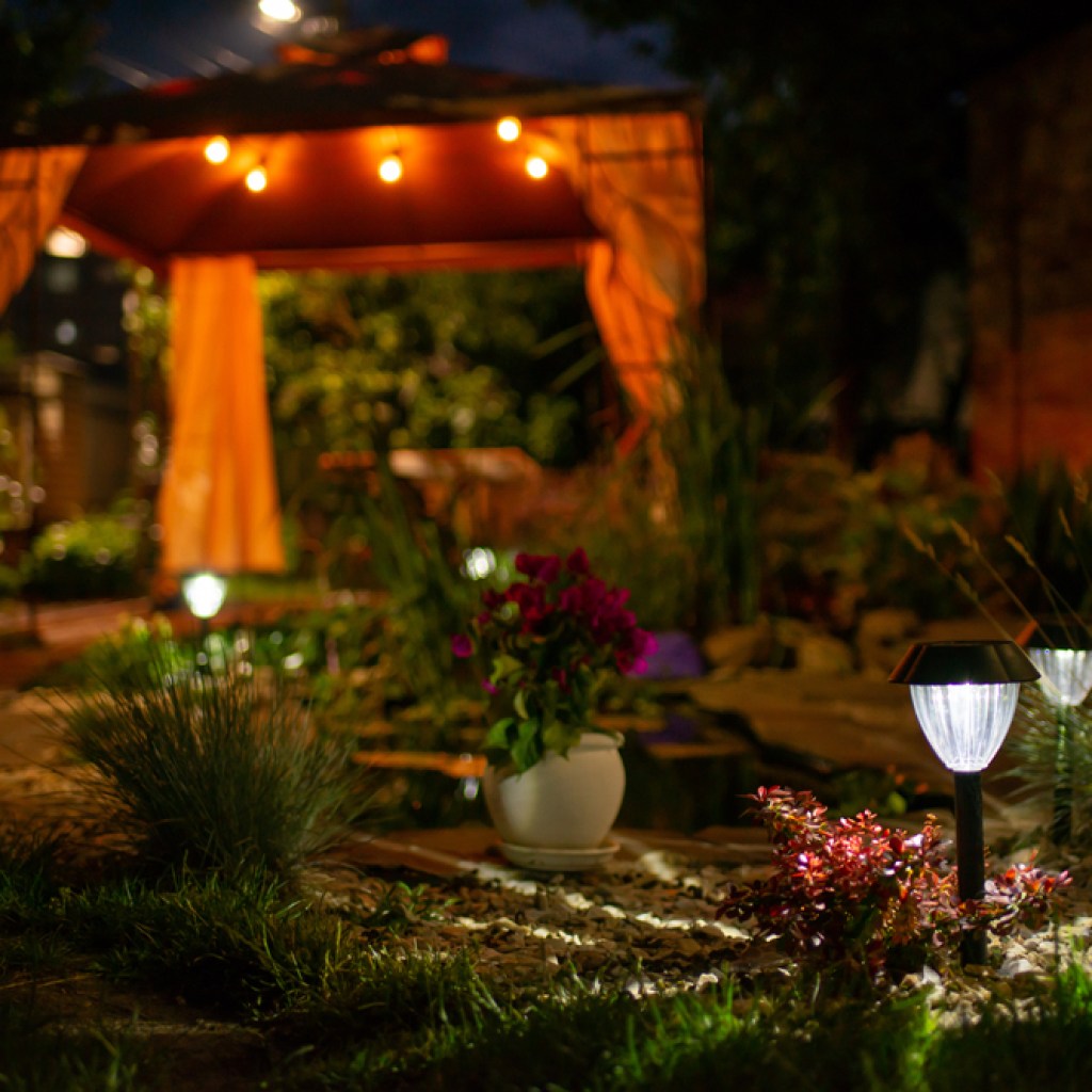 Small decorative solar garden lights in flower bed garden