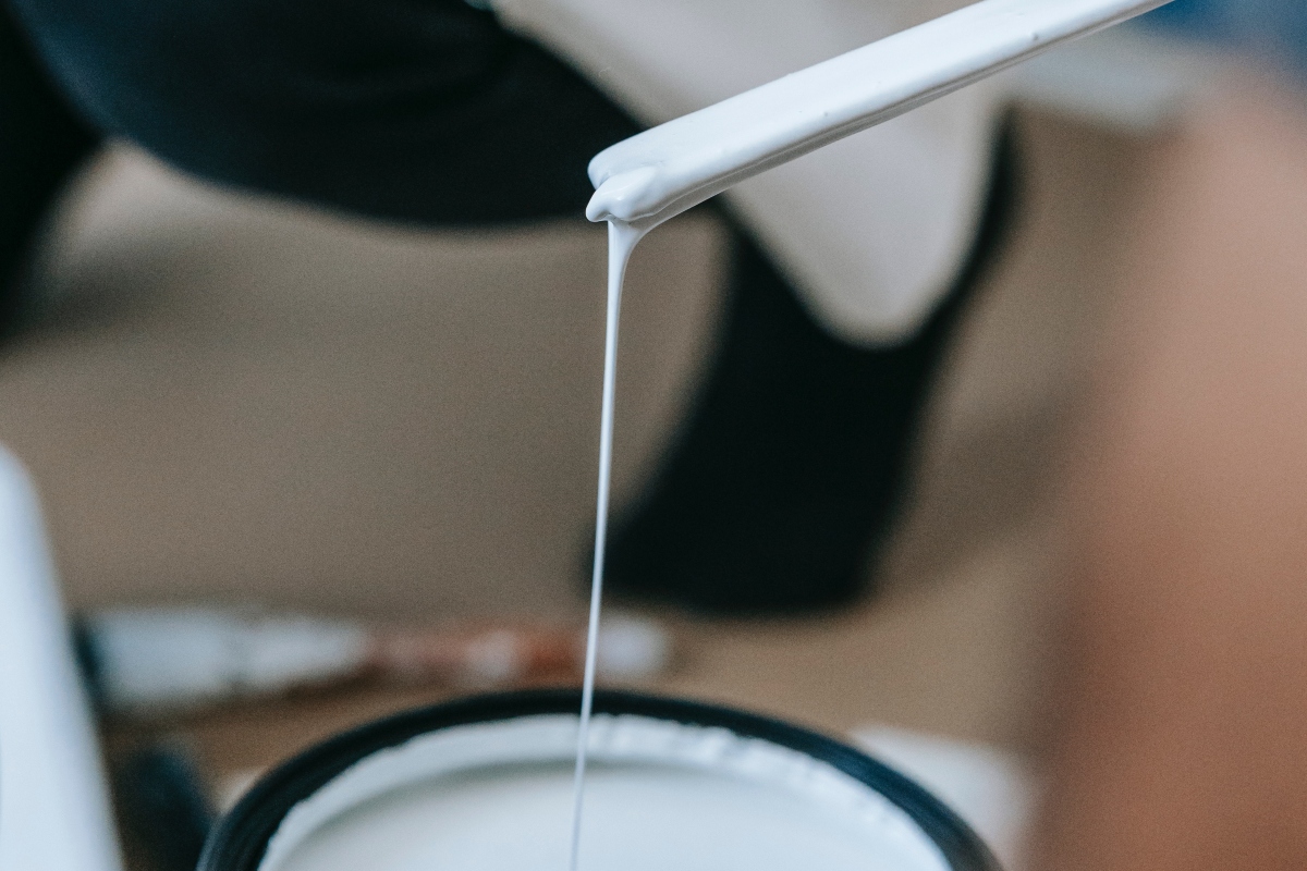 white paint primer dripping into can