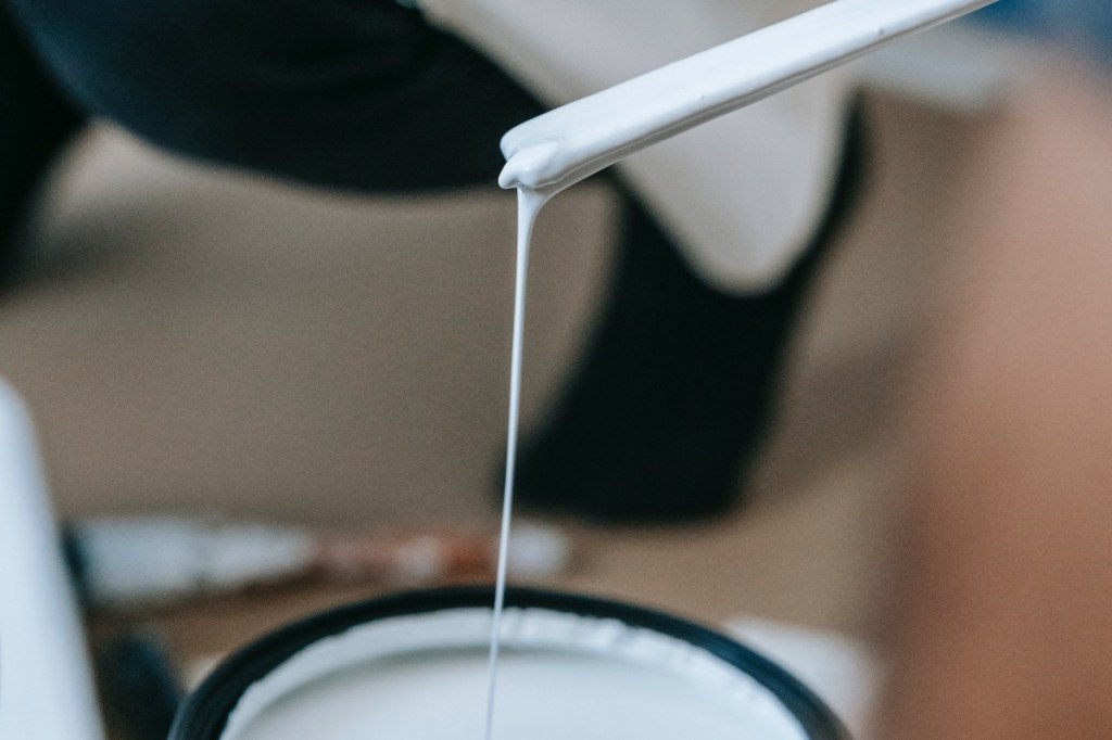 white paint primer dripping into can