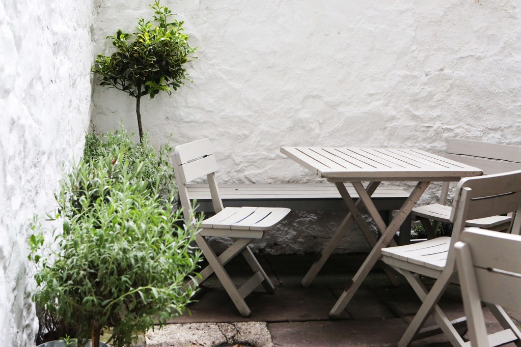 small patio with light colored walls and folding chairs