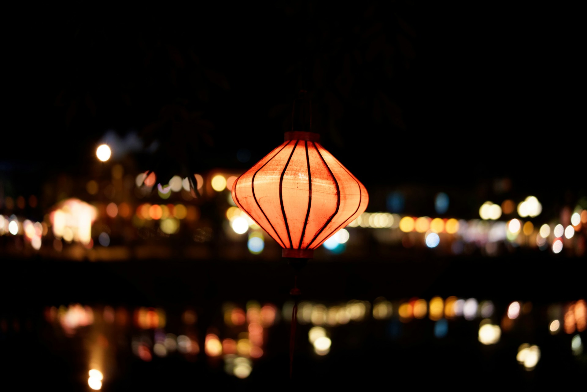 Paper lantern on ledge with city lights in the background