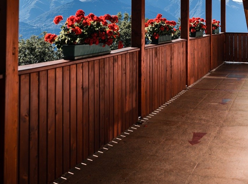 wood privacy deck railing with red flowers