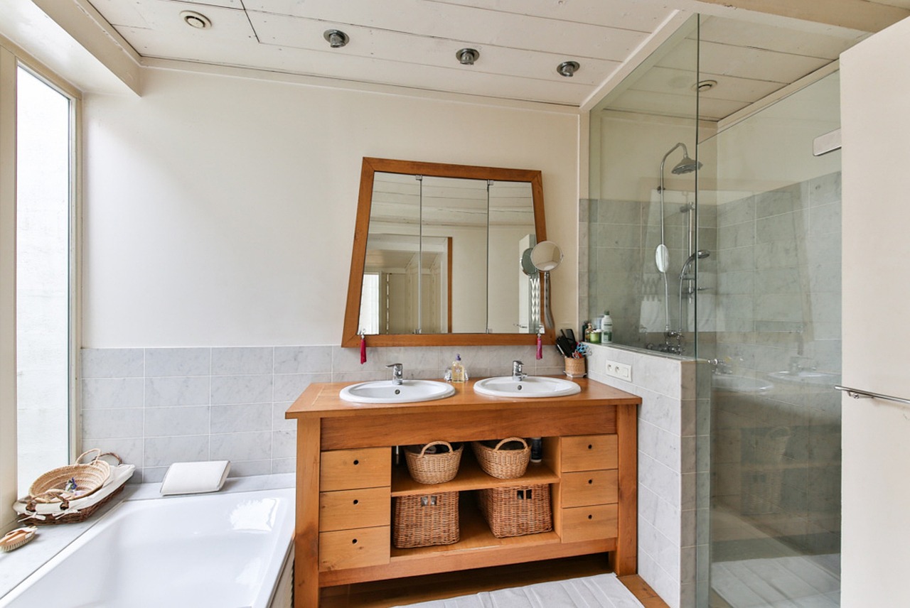 wood bathroom mirror and vanity with tub and glass shower