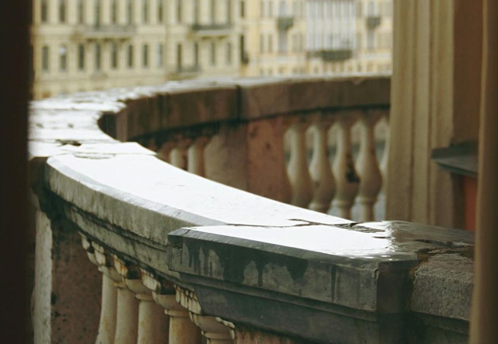 curved stone railing on city balcony