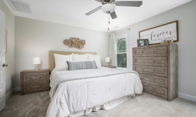 White farmhouse bedroom with minimalist design and a ceiling fan
