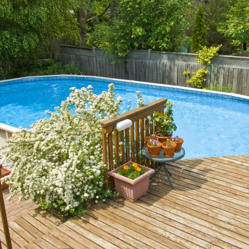 Above-ground pool with partial deck in backyard