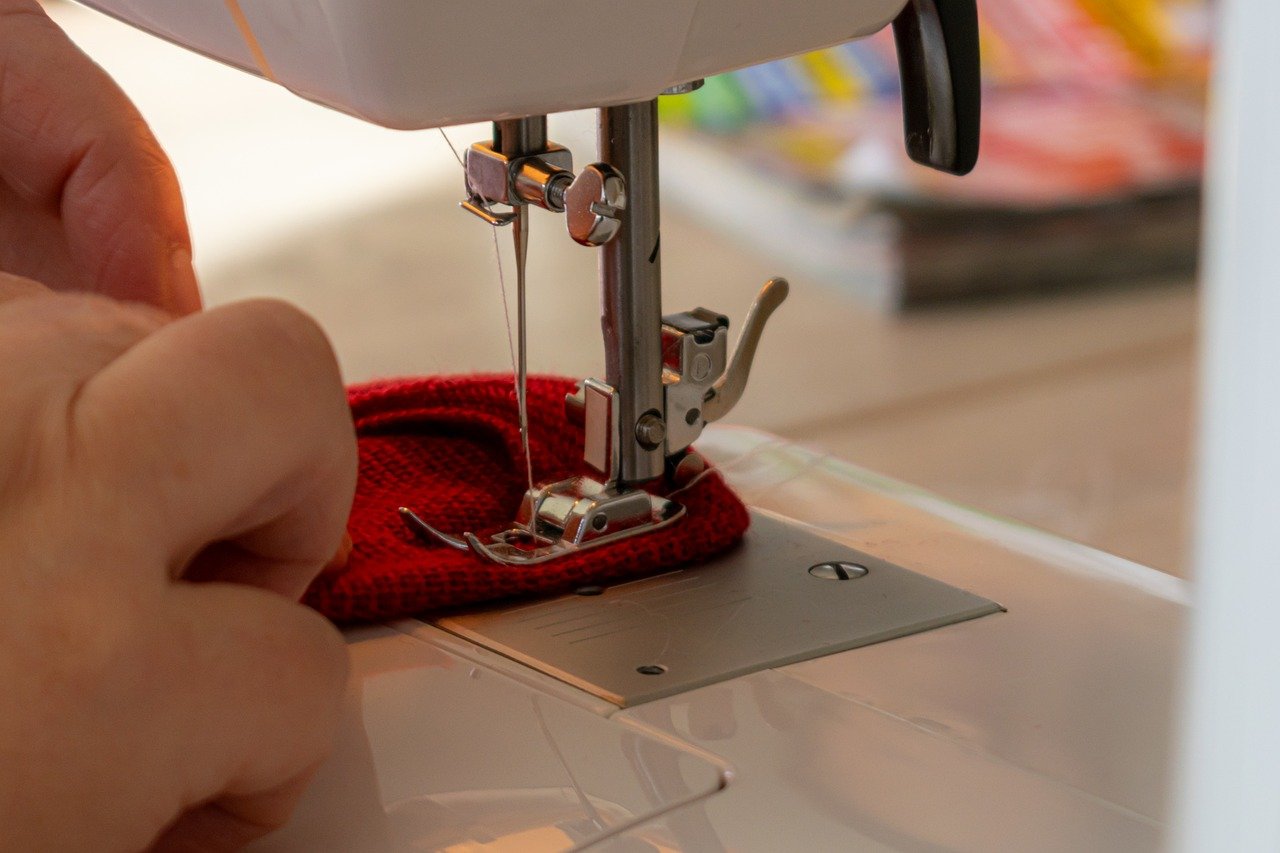Sewing a red fabric with a sewing machine