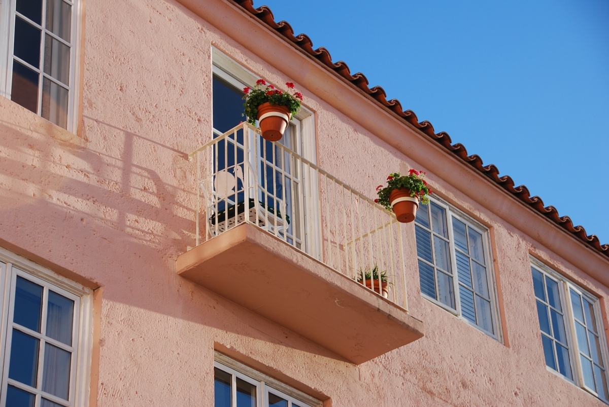 pink stucco building exterior with balcony