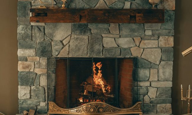 Stone fireplace in sitting area with dark, brown colors