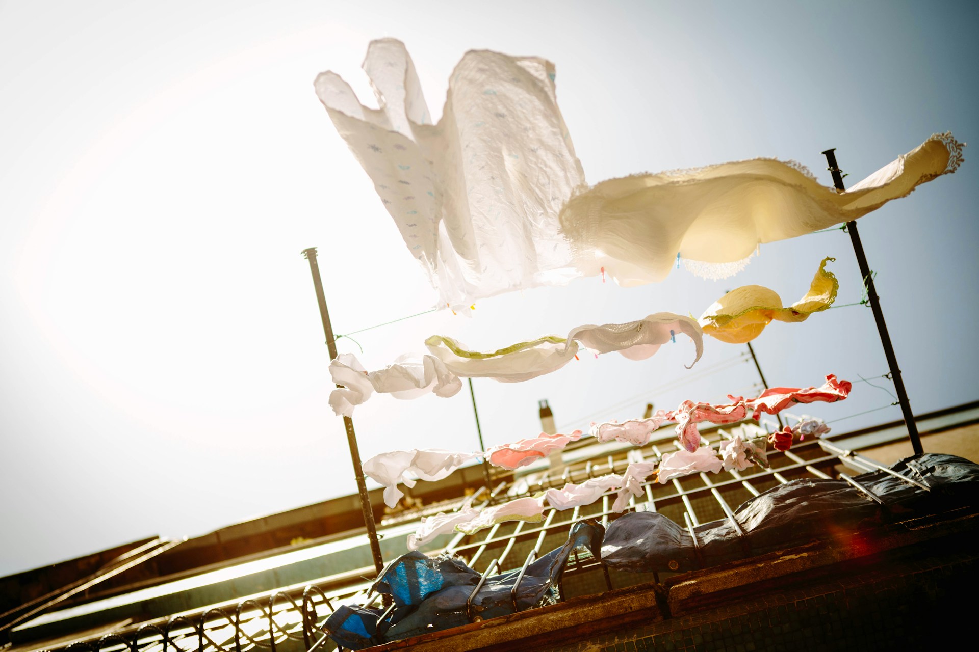 white laundry hanging on a clothes line from a balcony