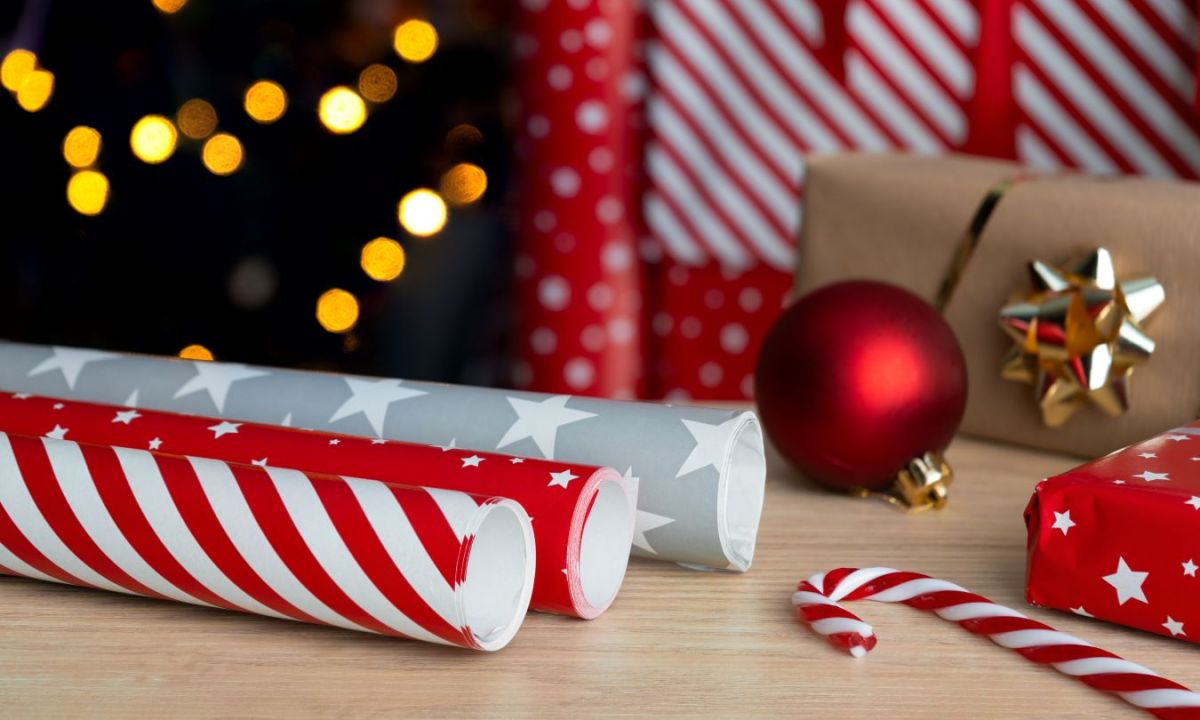 Rolls of holiday wrapping paper storage on wood surface