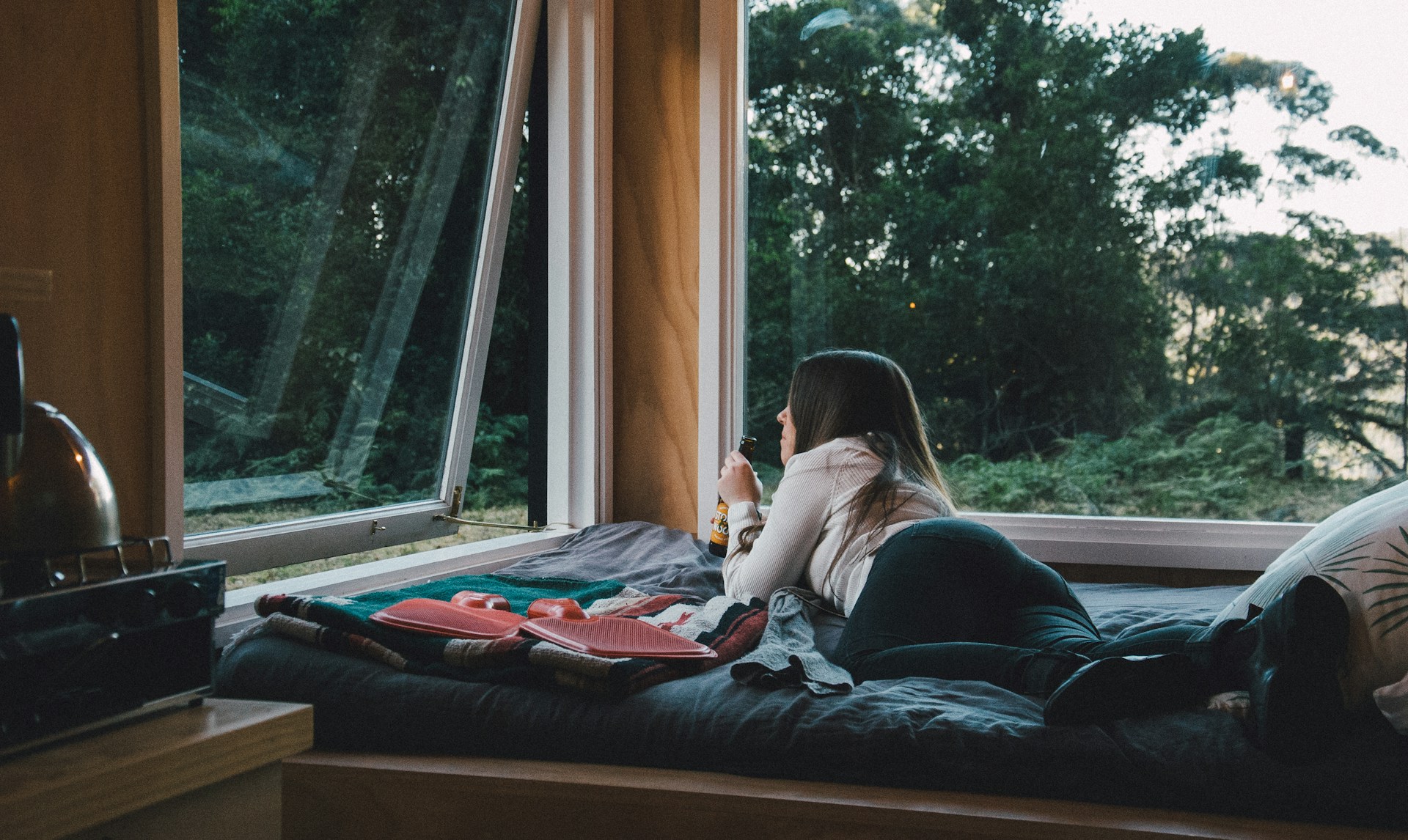 Woman on bed next to large awning window