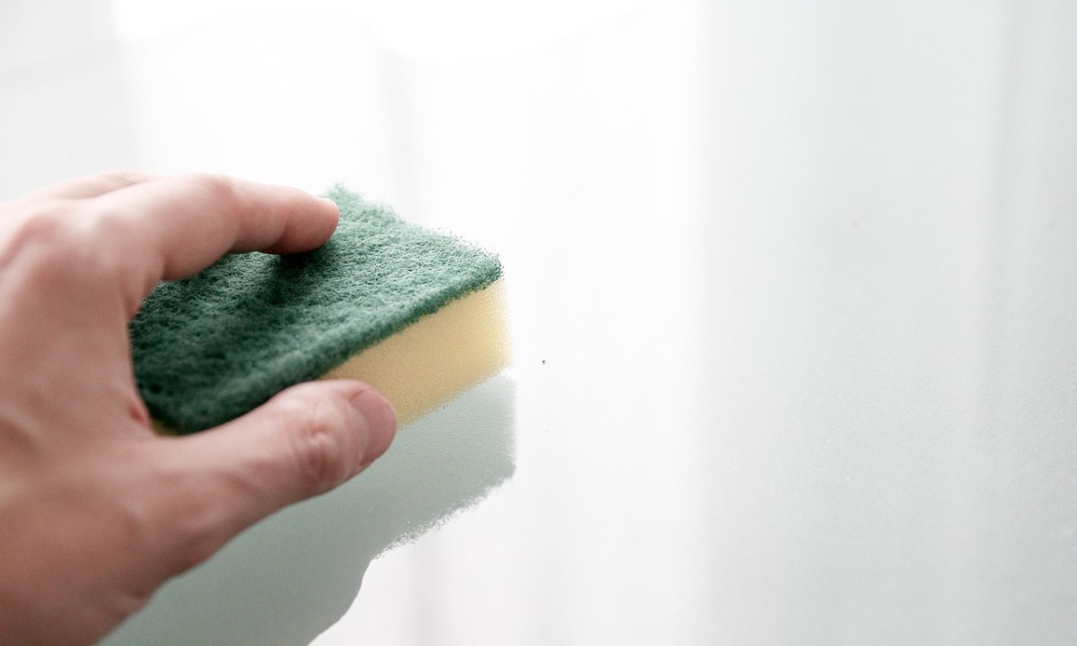Man using a sponge on a wall