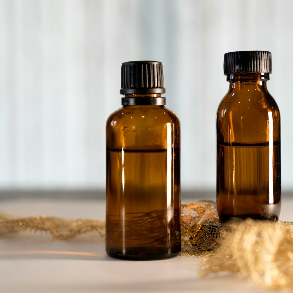 Two amber bottles with liquid on a white surface