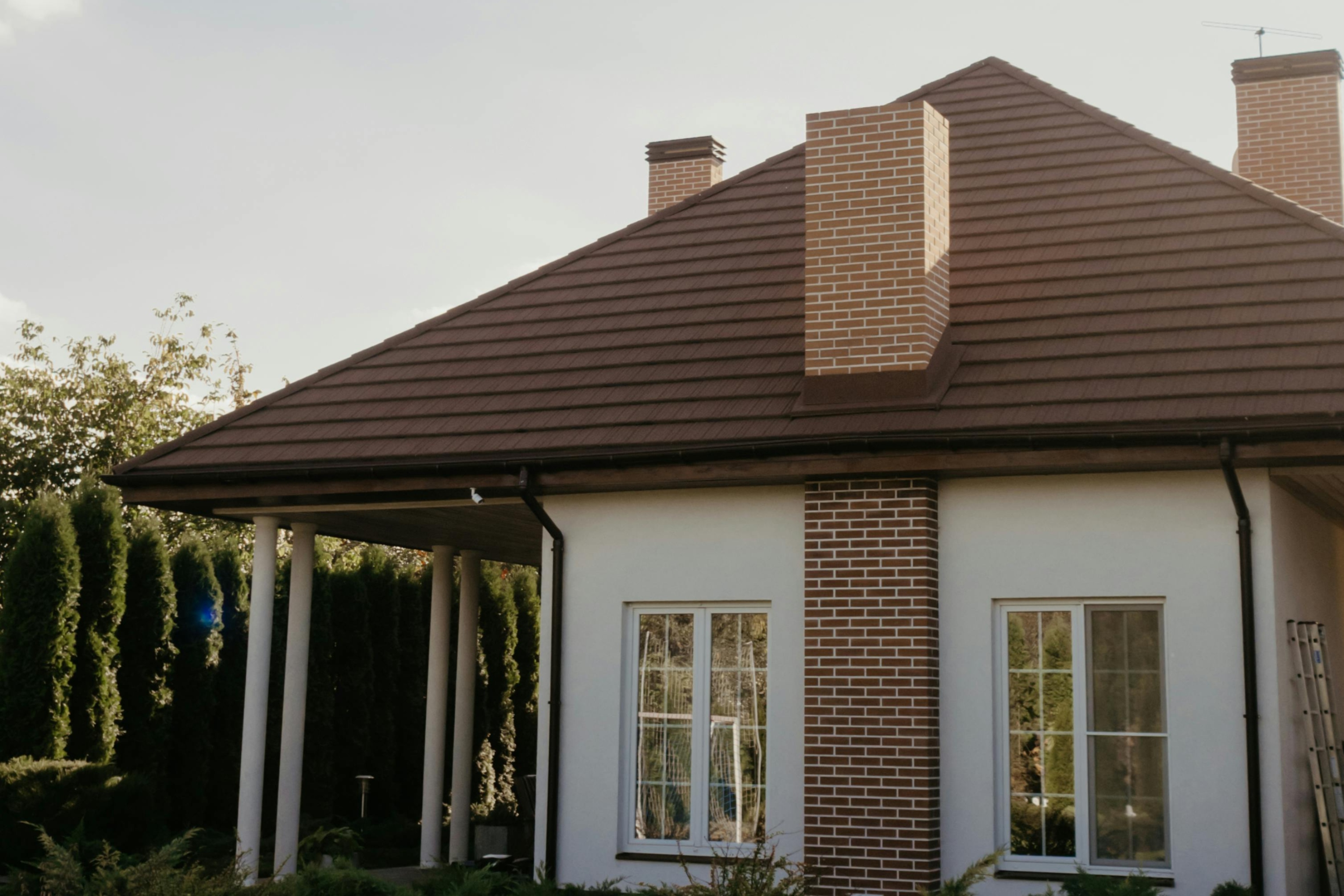small suburban house with brick chimney and brown roof